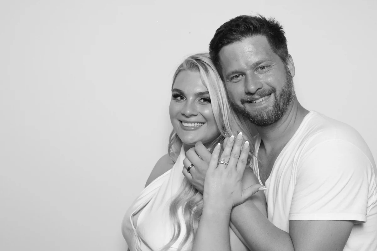 Kelsey and Jesse smiling together and showing their wedding rings