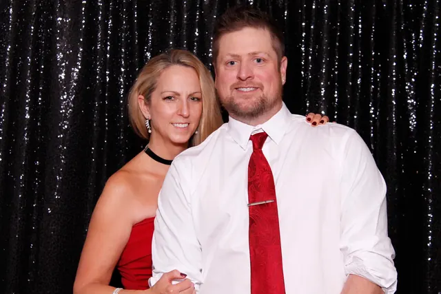 Guests enjoying a photo booth with a dark backdrop, photo 3