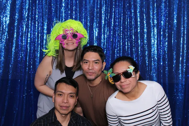 Guests enjoying a photo booth with a blue sequin backdrop, photo 1