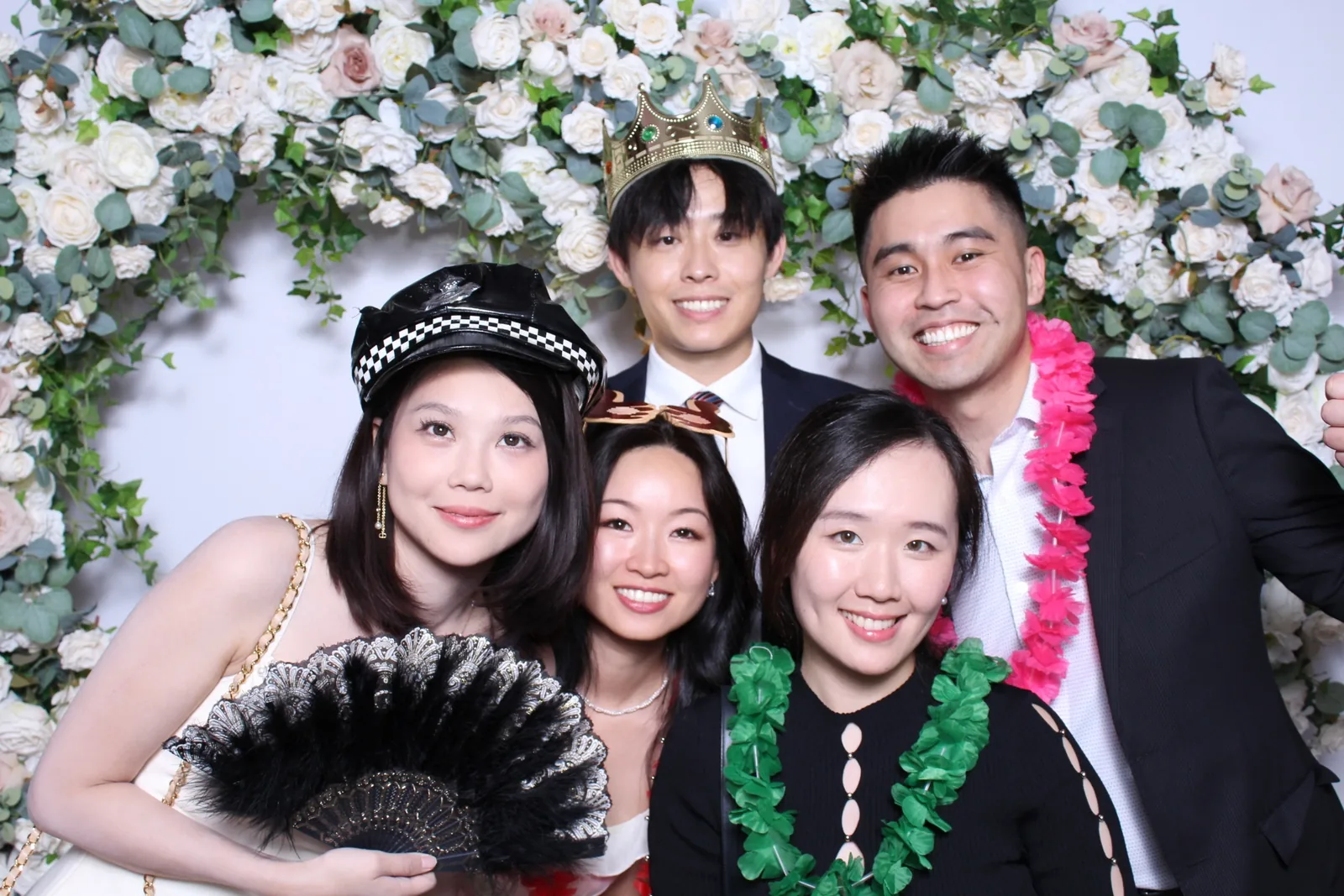 Guests enjoying a photo booth with a floral greenery backdrop, photo 4