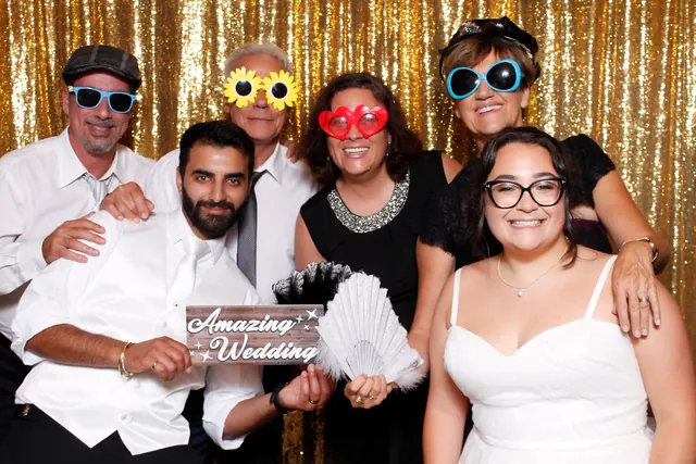 Guests enjoying a photo booth with a gold sequin backdrop, photo 1