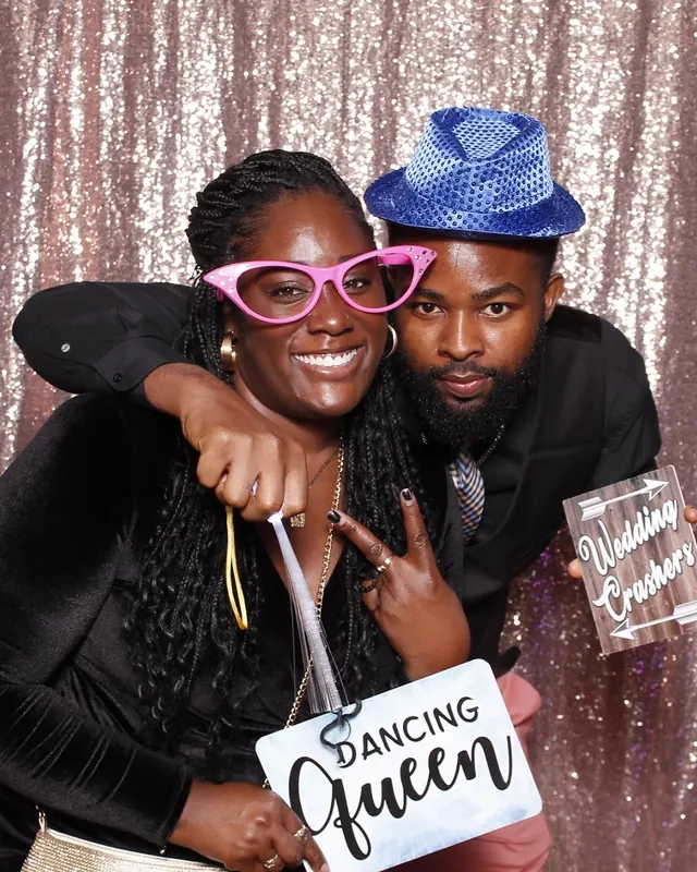 Guests enjoying a photo booth with a rose-gold sequin backdrop, photo 1