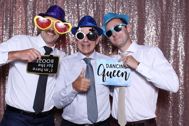 Guests enjoying a photo booth with a rose-gold sequin backdrop, photo 2