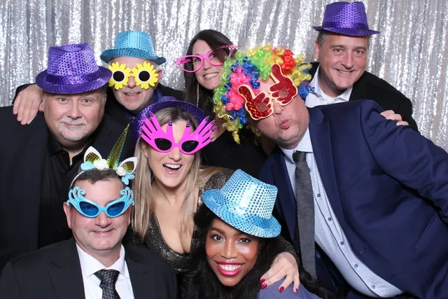 Guests enjoying a photo booth with a silver sequin backdrop, photo 2