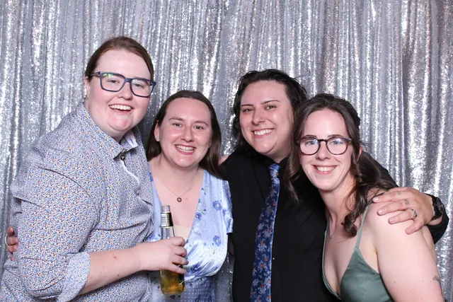 Guests enjoying a photo booth with a silver sequin backdrop, photo 8