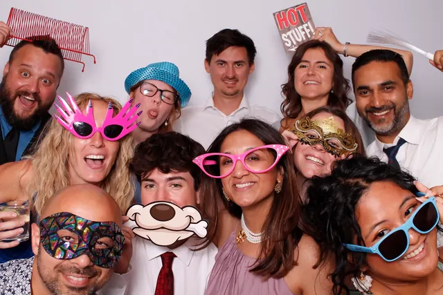 Guests enjoying a photo booth with a white neutral backdrop, photo 1