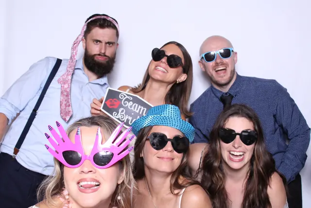 Guests enjoying a photo booth with a white neutral backdrop, photo 15