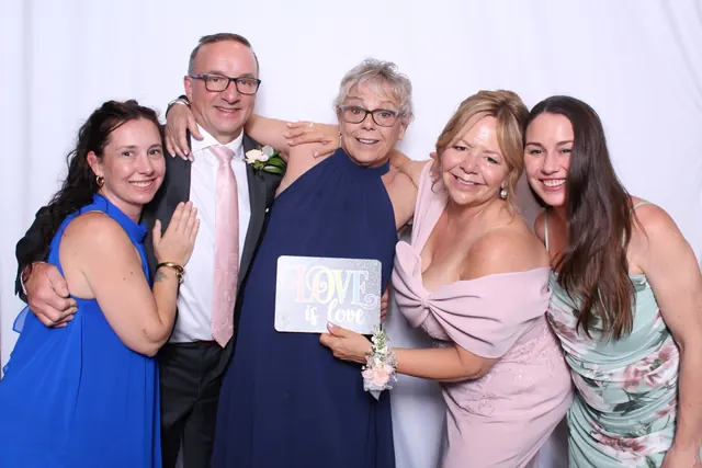 Guests enjoying a photo booth with a white neutral backdrop, photo 16