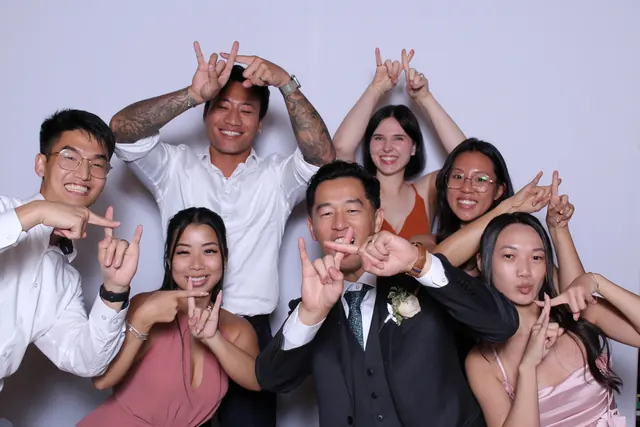 Guests enjoying a photo booth with a white neutral backdrop, photo 17