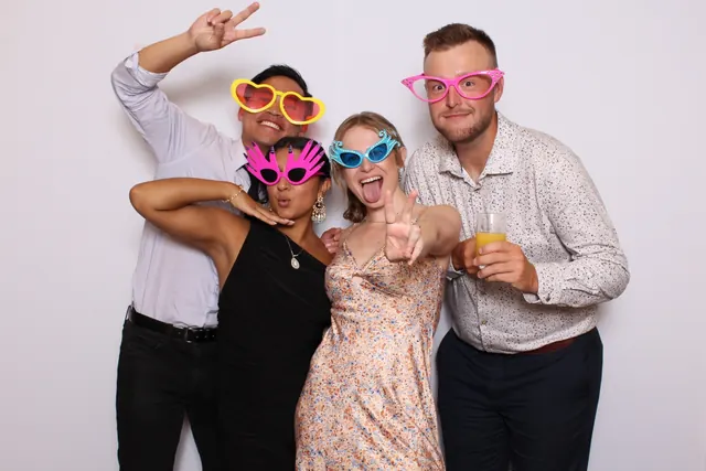 Guests enjoying a photo booth with a white neutral backdrop, photo 20
