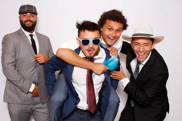 Guests enjoying a photo booth with a white neutral backdrop, photo 23
