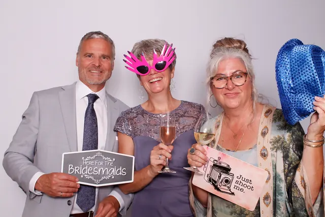 Guests enjoying a photo booth with a white neutral backdrop, photo 30