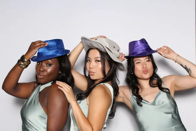 Guests enjoying a photo booth with a white neutral backdrop, photo 35