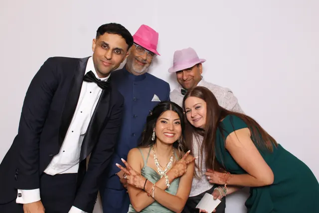 Guests enjoying a photo booth with a white neutral backdrop, photo 37