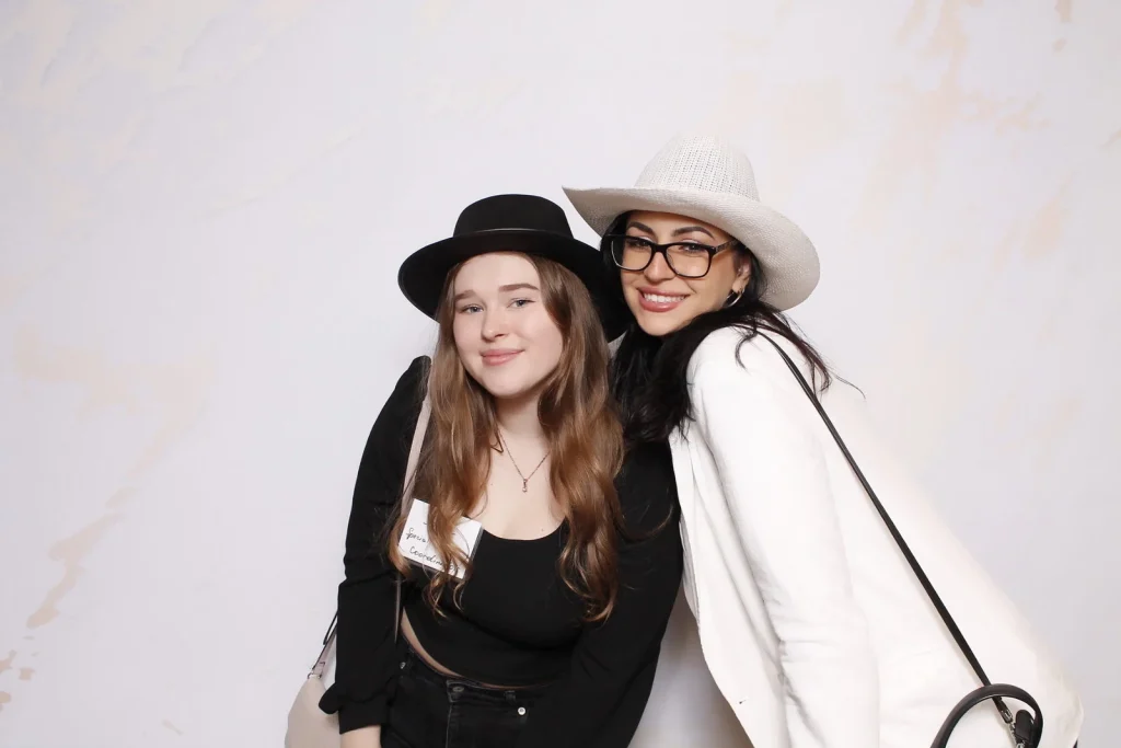 Two EPN Social guests posing together in black and white photo booth hats