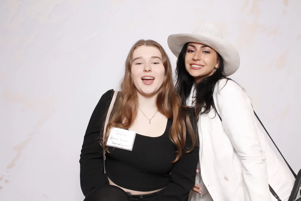 Two EPN Social guests smiling together against a light white photo booth background